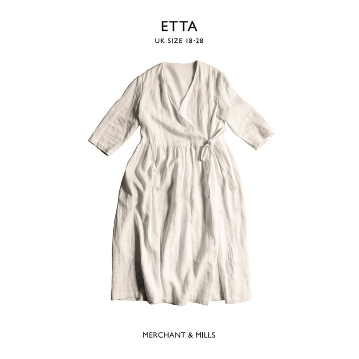 An off-white linen wrap dress with three-quarter sleeves and a tie waist, shown flat against a white background with brand text 'ETTA' and 'MERCHANT & MILLS'.