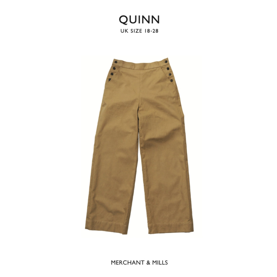 A pair of tan wide-leg trousers with decorative dark buttons on the waistband, shown flat against a white background with 'QUINN UK SIZE 18-28' at the top and 'MERCHANT & MILLS' at the bottom.