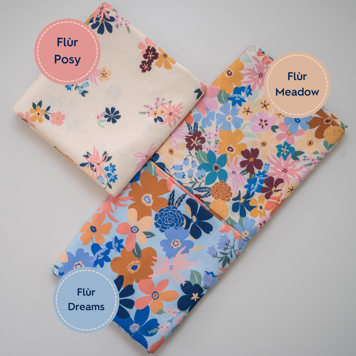Three floral fabric swatches labeled 'Flör Posy', 'Flör Meadow', and 'Flör Dreams' on a gray background.