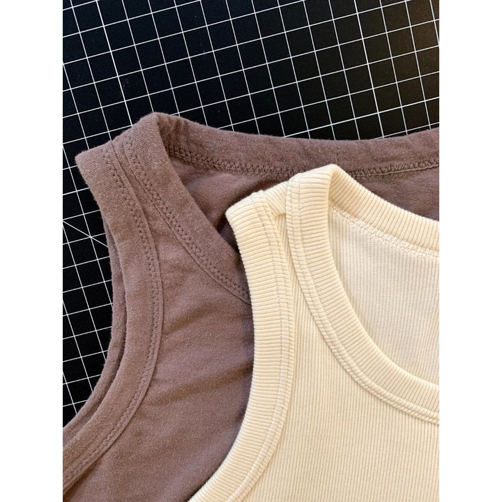 Close-up of brown and beige tank tops on a grid background