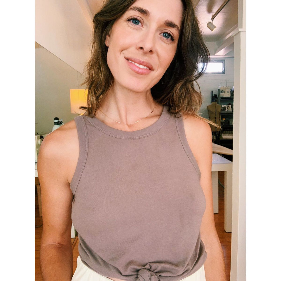 Woman wearing a brown tank top in an indoor setting
