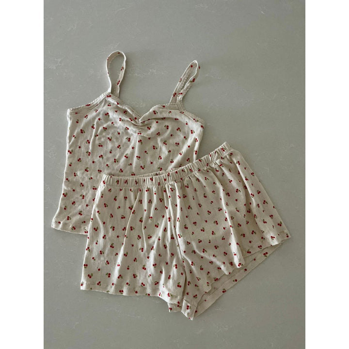 Set of pajama top and shorts with red floral pattern on a gray background