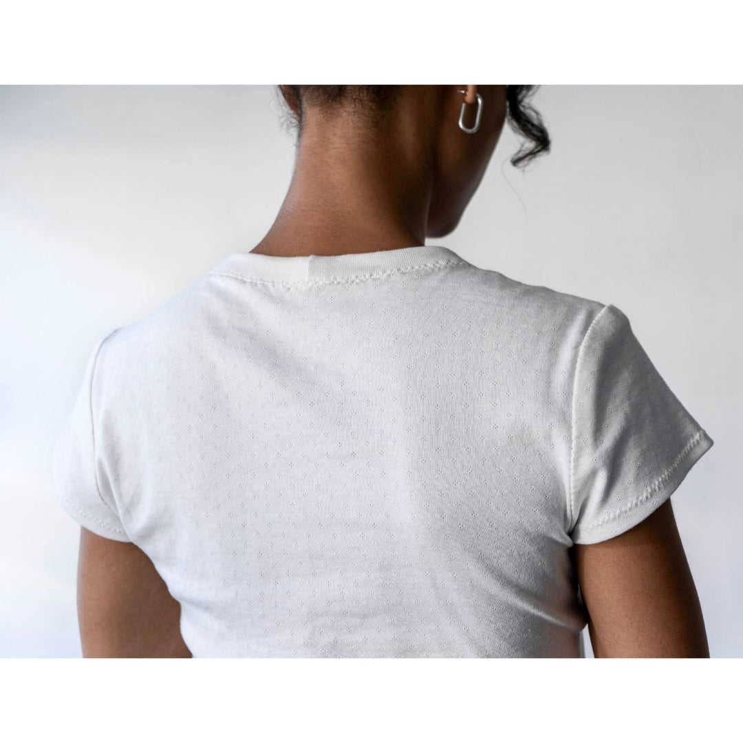 Person wearing a white t-shirt against a plain background