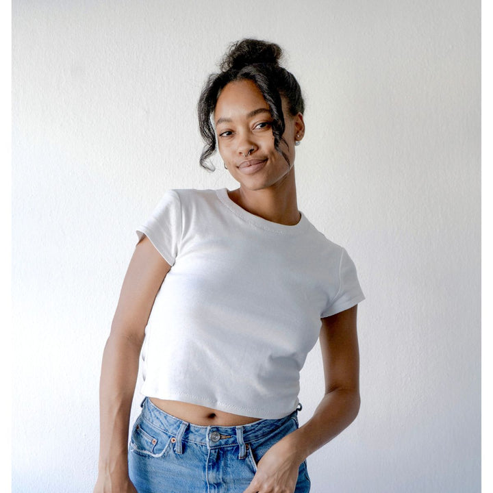 Person wearing a white t-shirt and blue jeans against a plain background