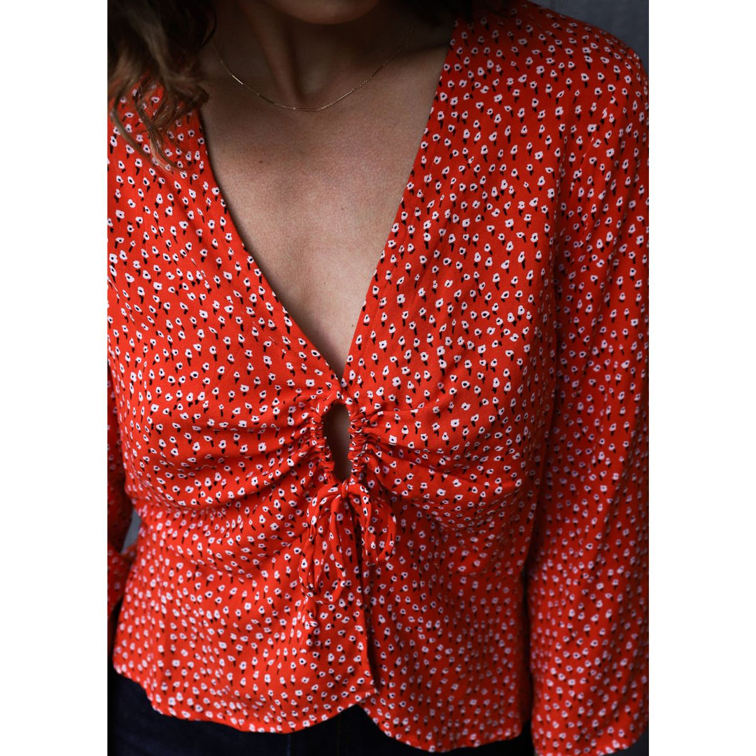 Red floral blouse with a deep neckline on a white background