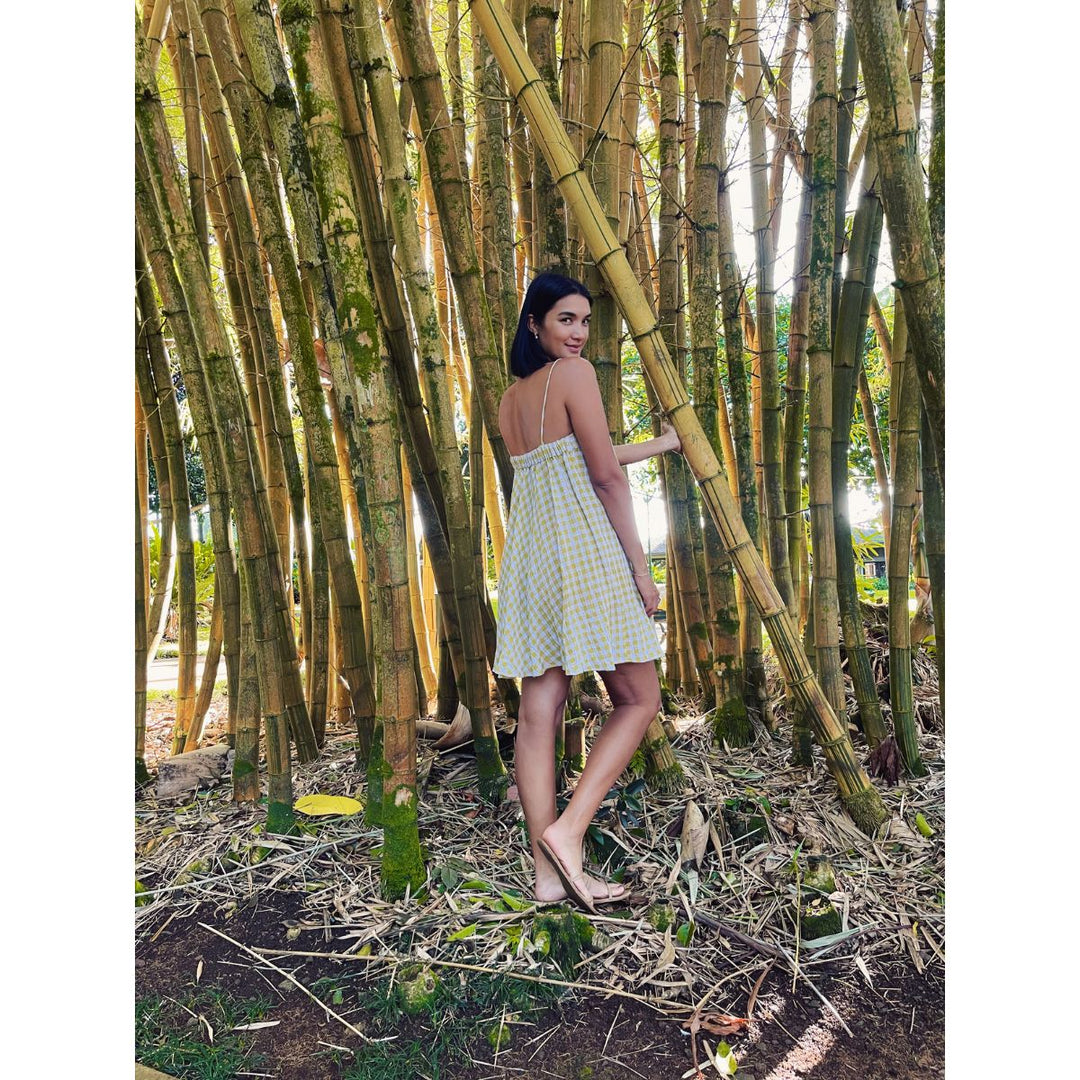 Woman in a white dress standing among tall bamboo plants