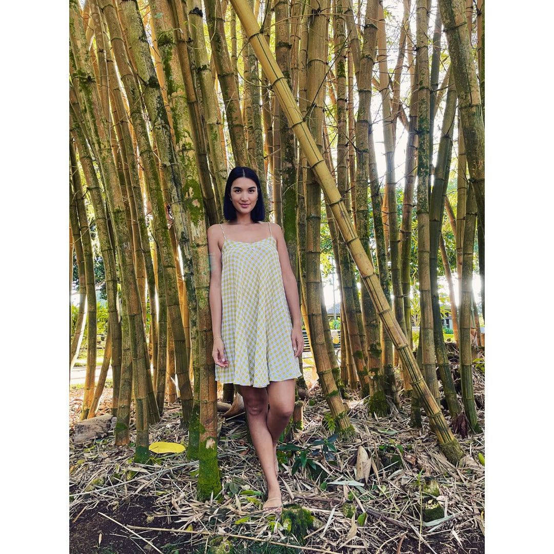 Woman in a dress standing among tall bamboo trees
