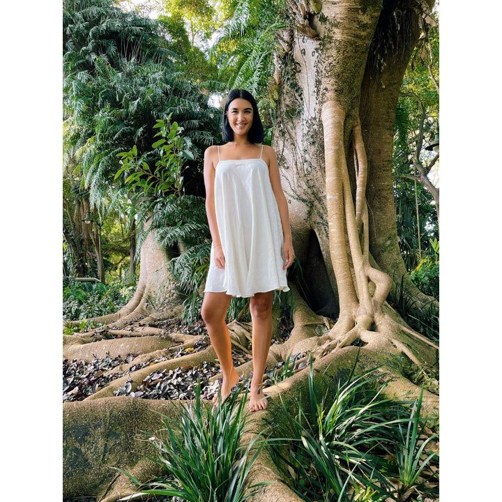 Woman in a white dress standing in a tropical forest