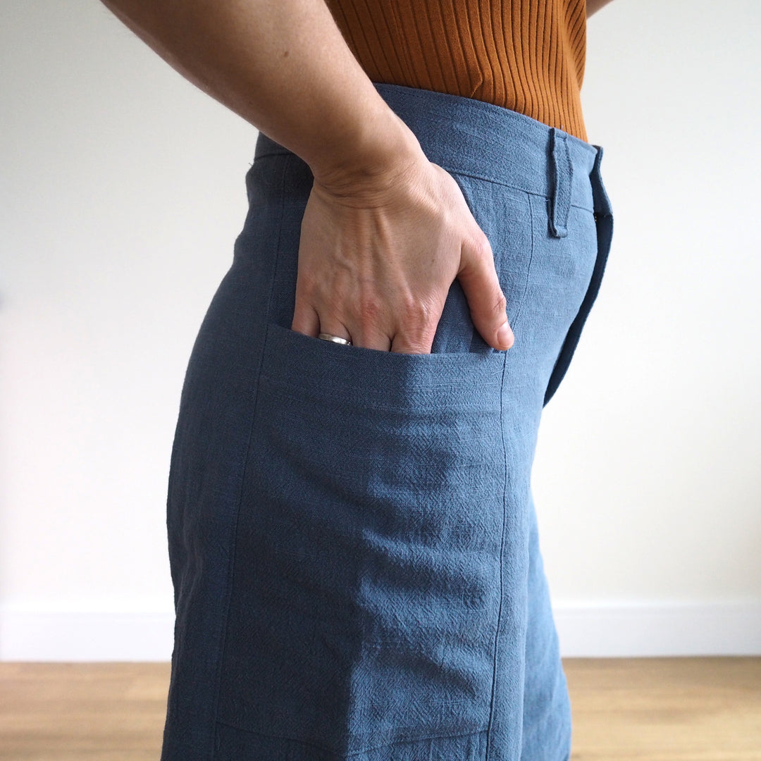 Person wearing blue pants with a plain background