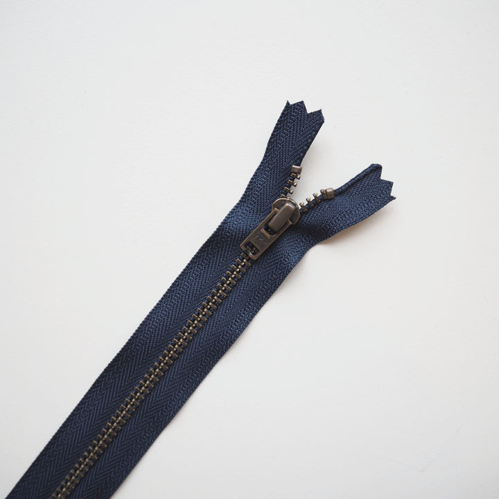 Navy blue zipper on a light gray background