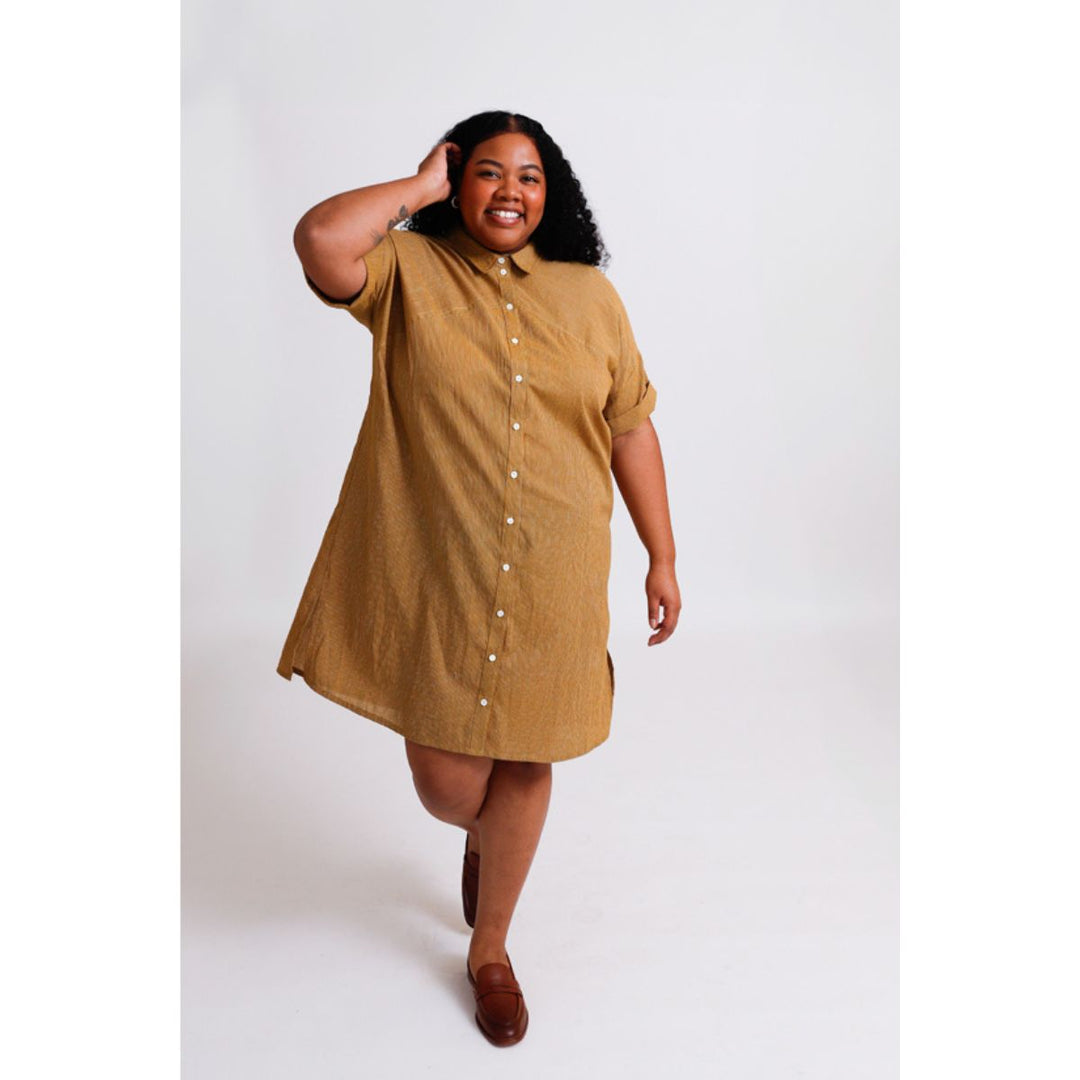 Woman wearing a mustard yellow dress on a white background