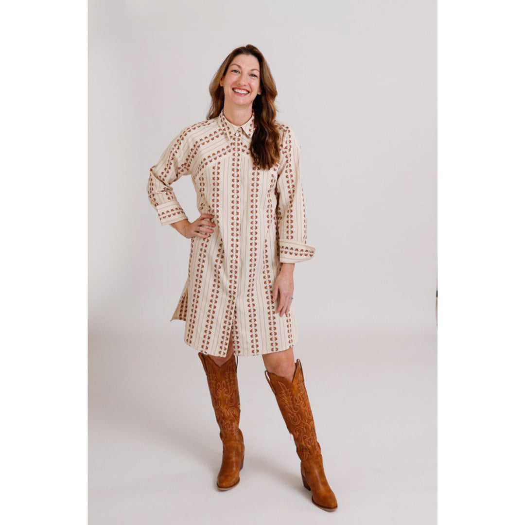 Woman wearing a patterned dress and brown knee-high boots on a white background