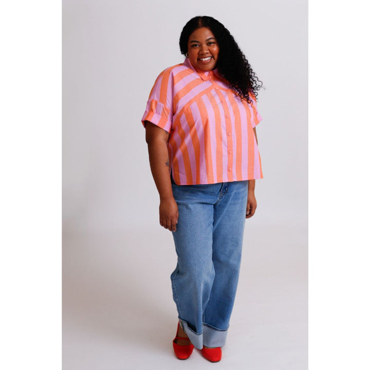Person wearing a striped shirt and jeans on a plain background