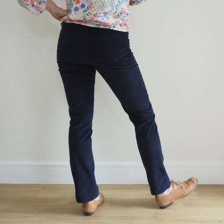 Model showing the back of the trousers. Yoke shaping and large patch pockets on black Eleonore trousers