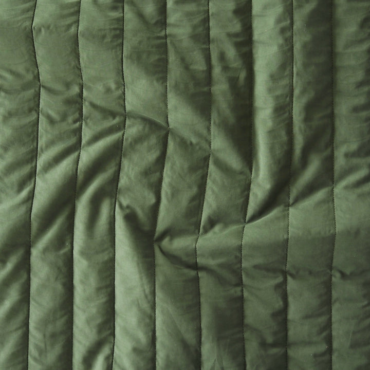 Close-up of green quilted fabric with a textured pattern