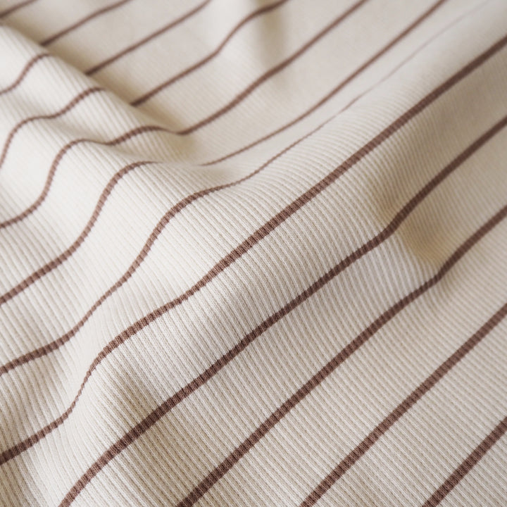 Striped ribbed cotton jersey fabric with brown lines on a beige background