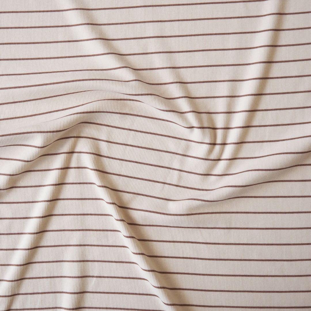 Striped ribbed cotton jersey fabric with brown lines on a beige background