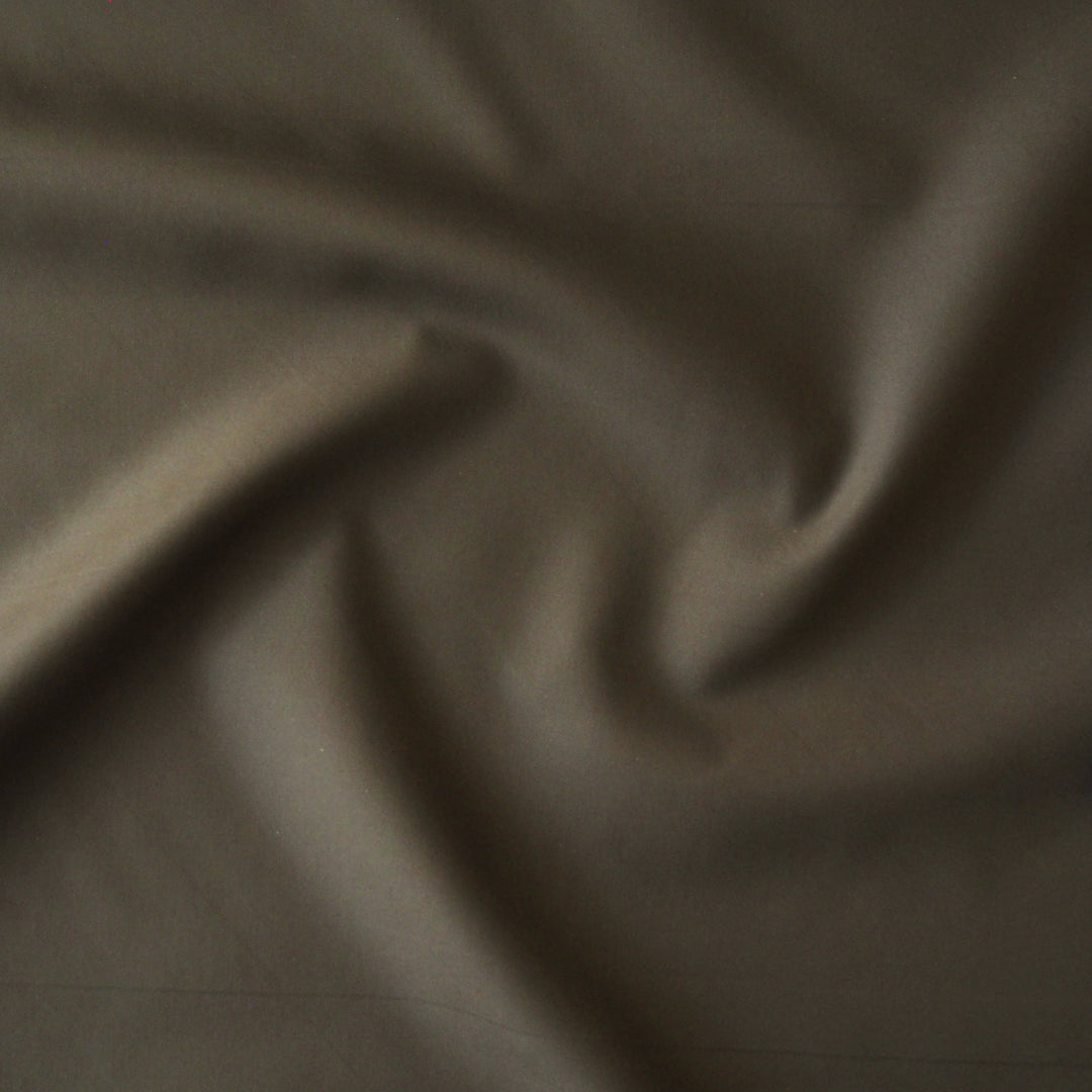 Khaki waxed cotton fabric with water-resistant finish for outerwear sewing.