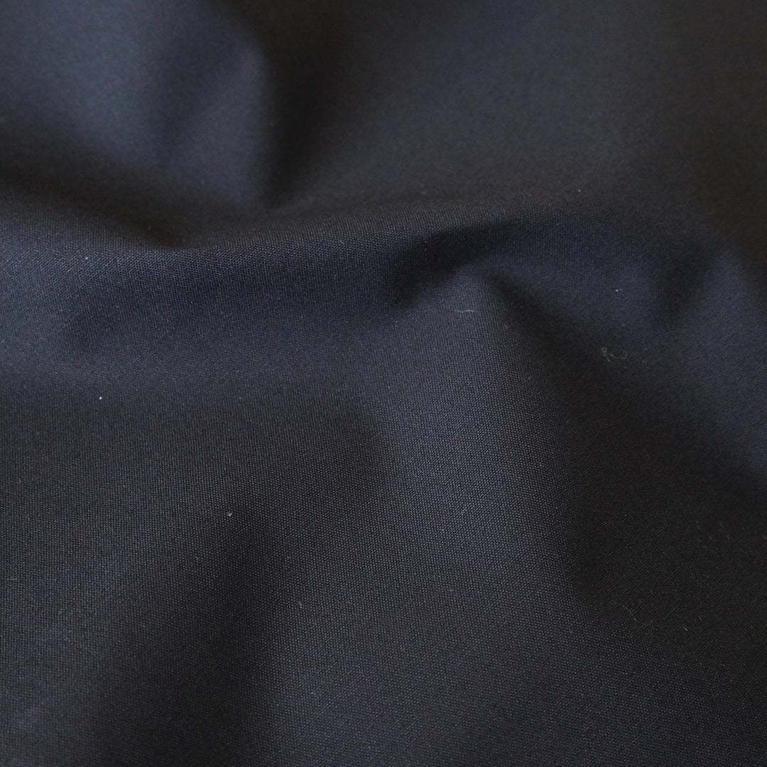 Navy waxed cotton fabric with water-resistant finish for outerwear sewing.