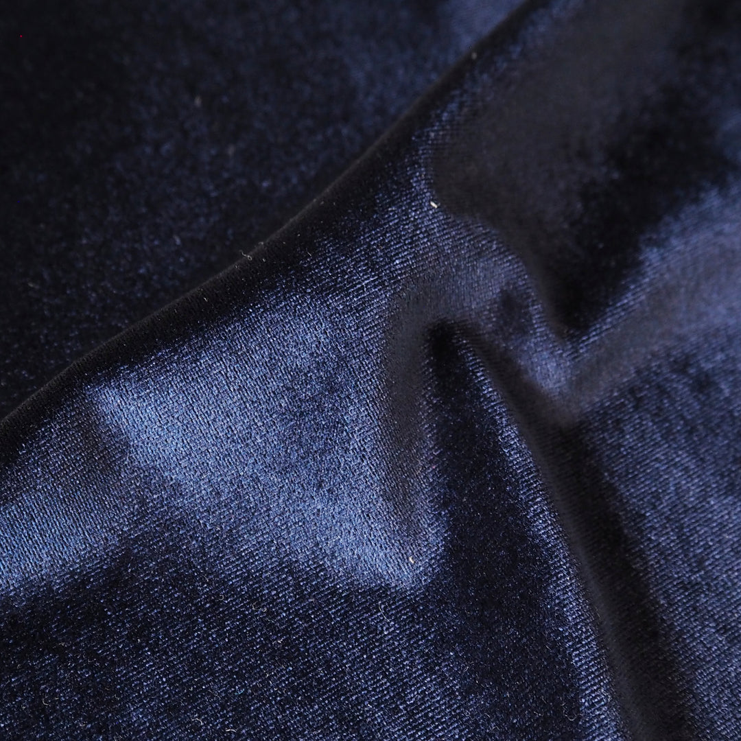 Navy blue stretch velour fabric with soft sheen for dressmaking.