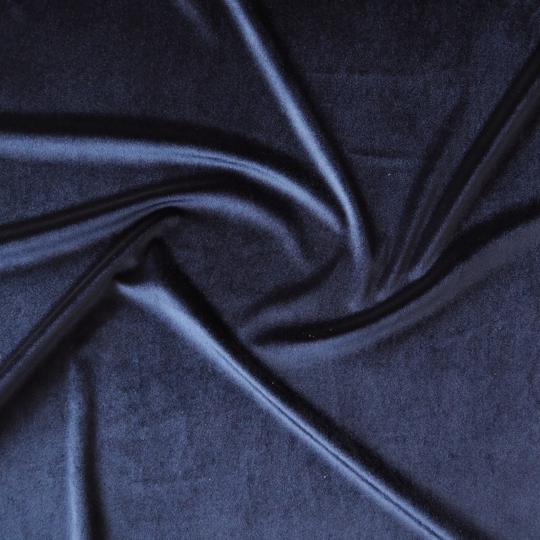 Navy blue stretch velour fabric with soft sheen for dressmaking.