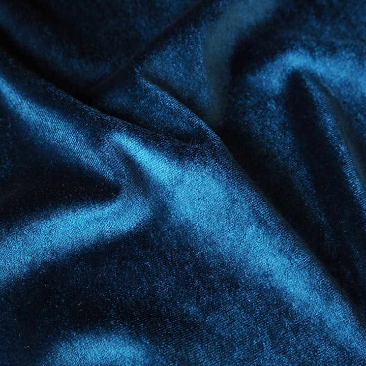 Peacock blue stretch velour fabric with soft sheen for dressmaking.