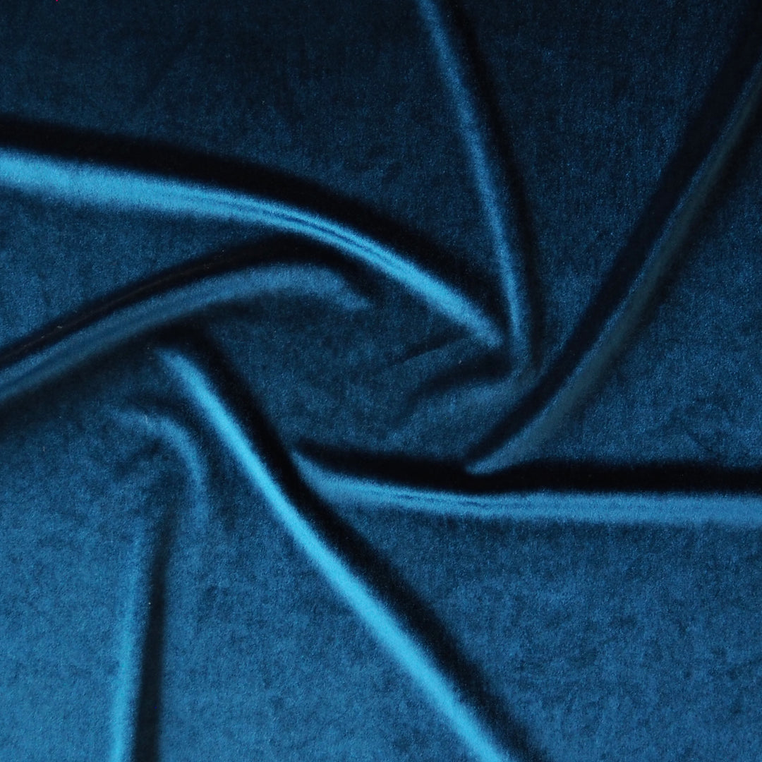 Peacock blue stretch velour fabric with soft sheen for dressmaking.
