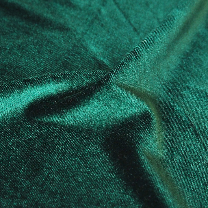 Emerald green stretch velour fabric with soft sheen for dressmaking.