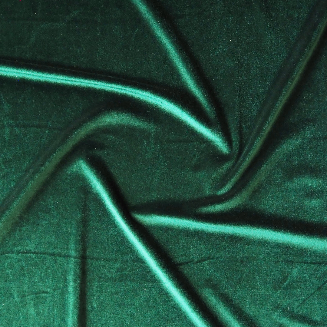 Emerald green stretch velour fabric with soft sheen for dressmaking.