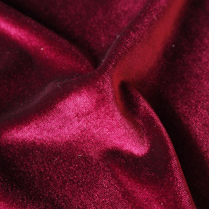 Wine red stretch velour fabric with soft sheen for dressmaking.