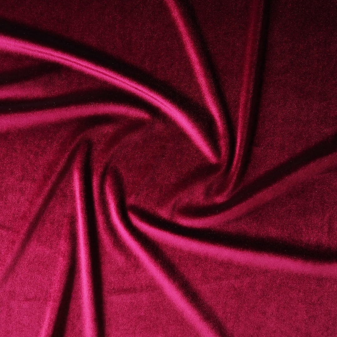 Wine red stretch velour fabric with soft sheen for dressmaking.