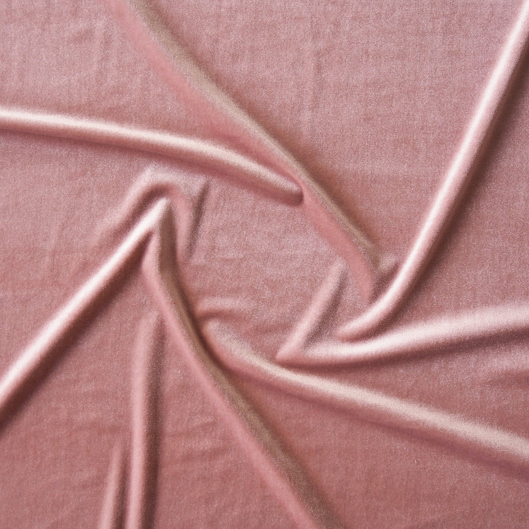 Rose pink stretch velour fabric with soft sheen for dressmaking.