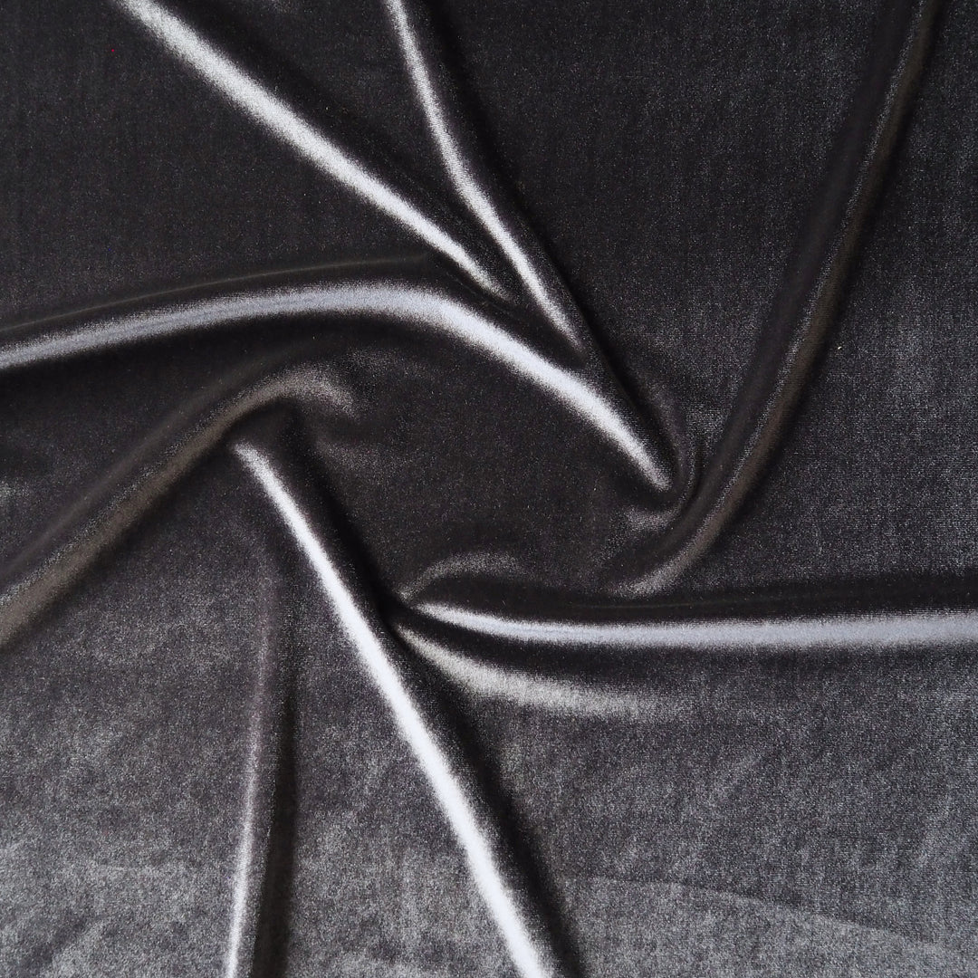 Charcoal grey stretch velour fabric with soft sheen for dressmaking.