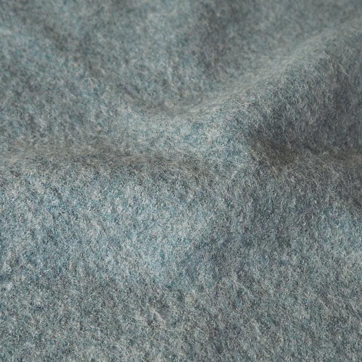 Close up of textured seafoam green boiled wool fabric