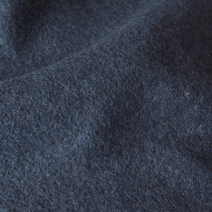 Close up of textured denim blue boiled wool fabric