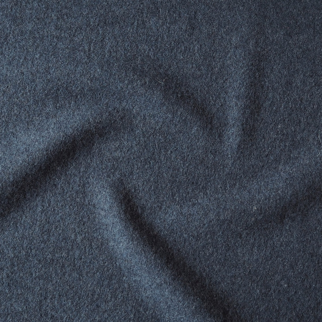 Close up of textured denim blue boiled wool fabric