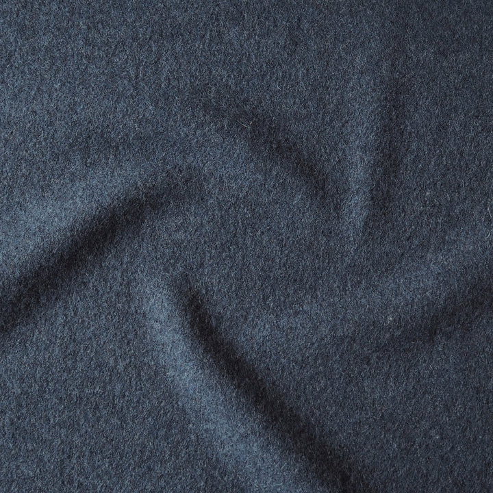 Close up of textured denim blue boiled wool fabric