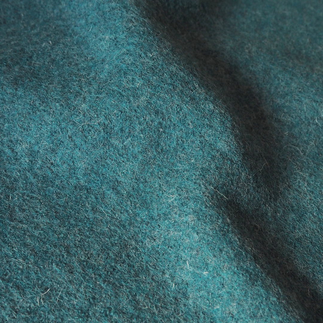Close up of textured teal boiled wool fabric