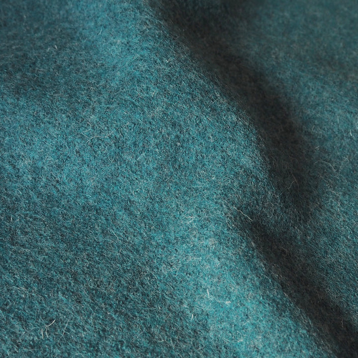 Close up of textured teal boiled wool fabric