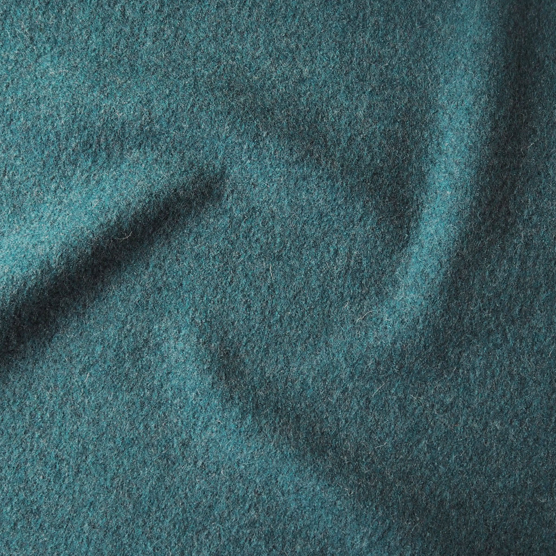 Close up of textured teal boiled wool fabric