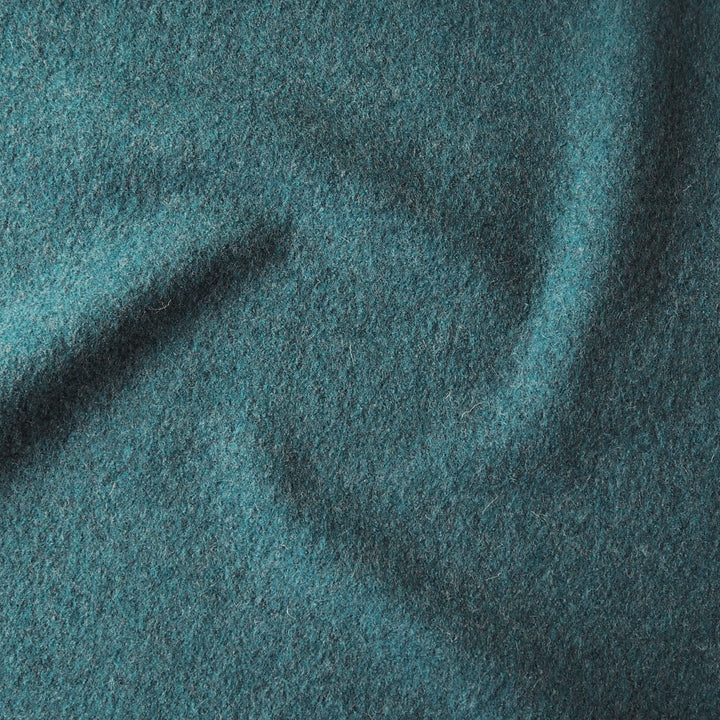 Close up of textured teal boiled wool fabric