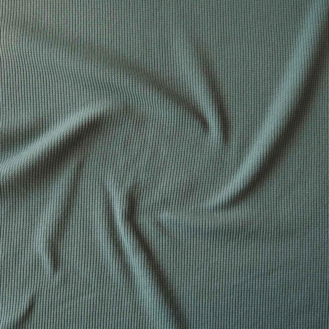 Close-up of sage green ribbed knitted fabric with visible texture