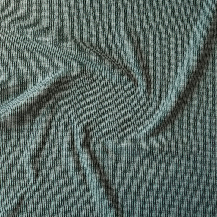 Close-up of sage green ribbed knitted fabric with visible texture