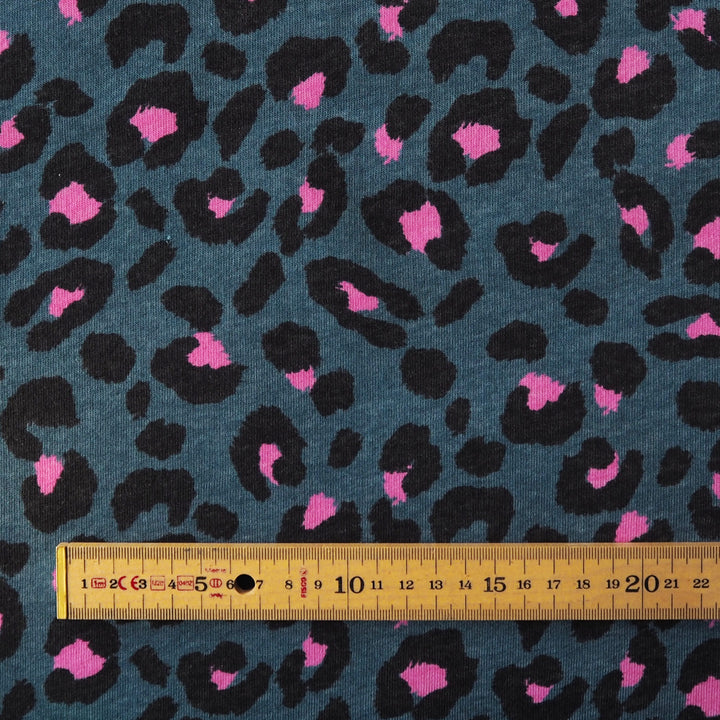 Leopard print fleeceback sweatshirt fabric with black and pink spots on an indigo blue background