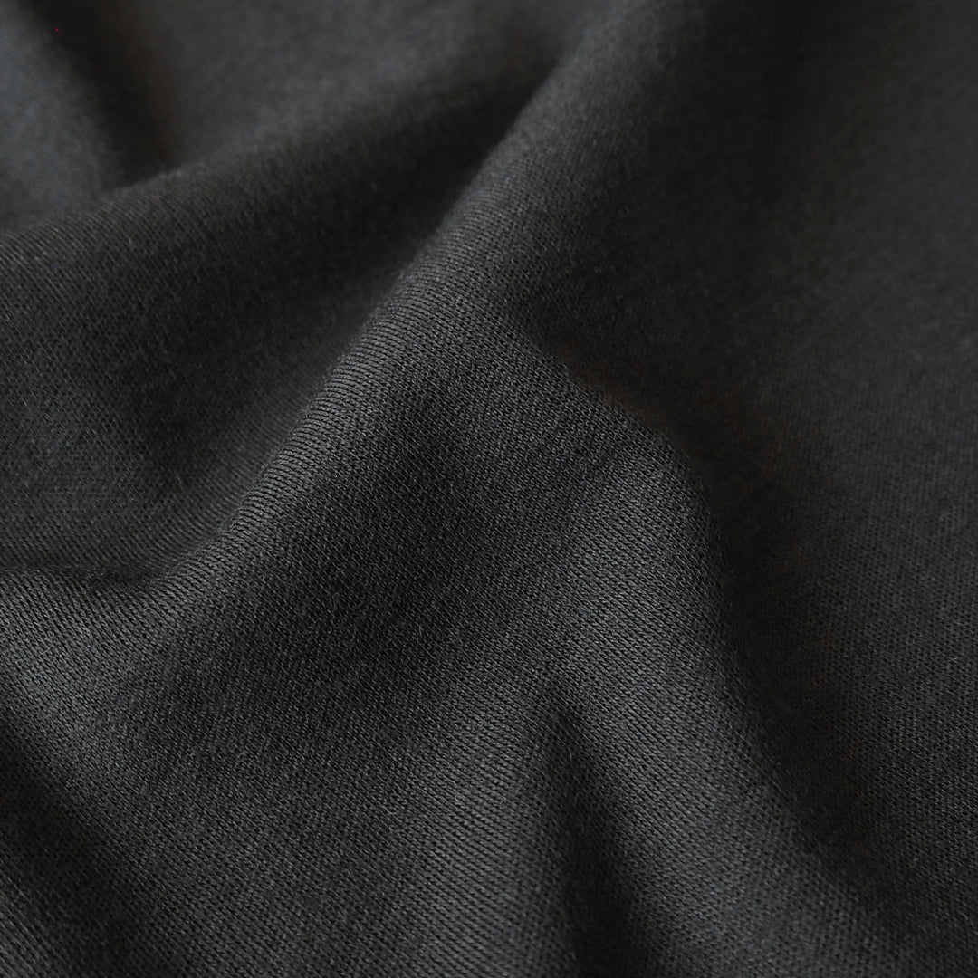 Close-up of black merino wool jersey fabric with visible texture