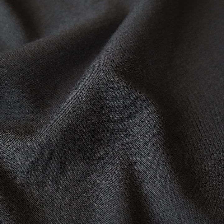 Close-up of black merino wool jersey fabric with visible texture