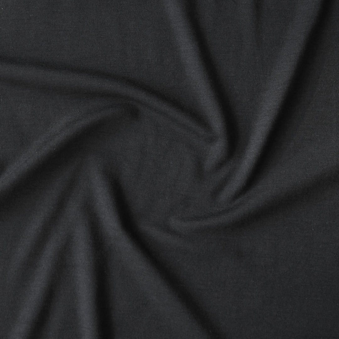 Close-up of black merino wool jersey fabric with visible texture