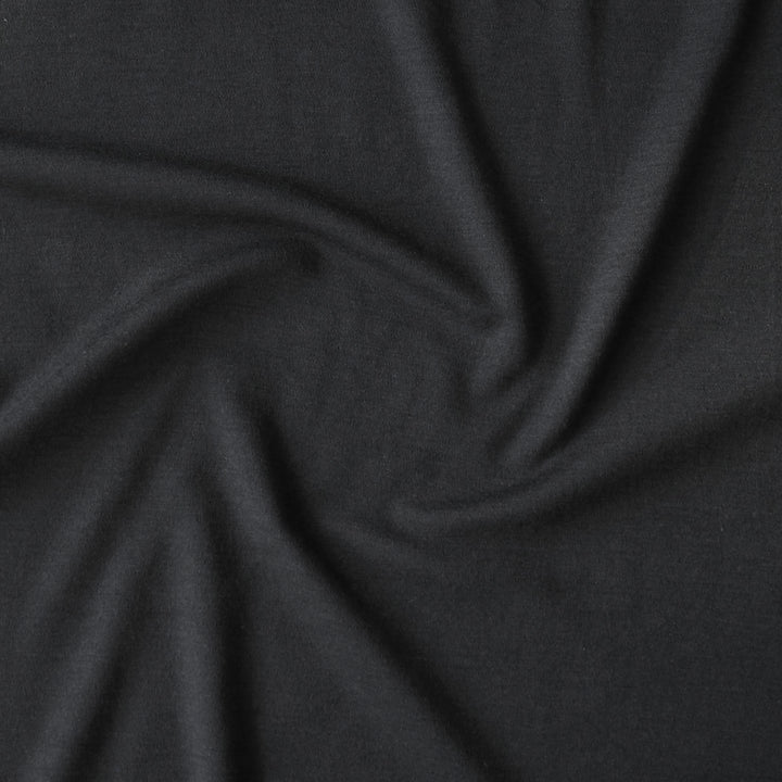 Close-up of black merino wool jersey fabric with visible texture