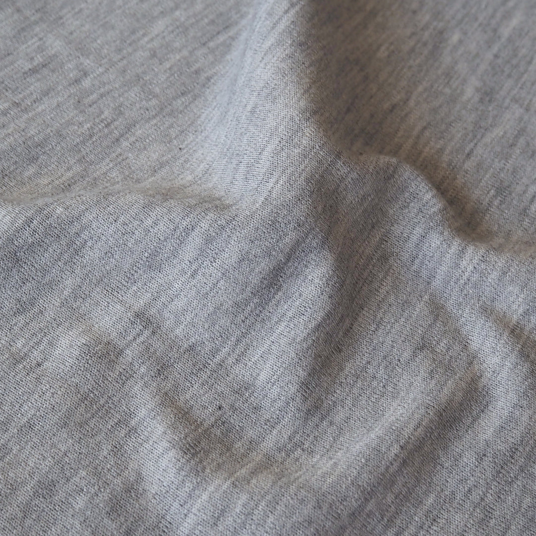 Close-up of grey merino wool jersey fabric with visible texture