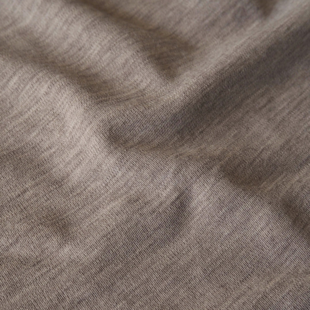 Close-up of beige merino wool jersey fabric with visible texture